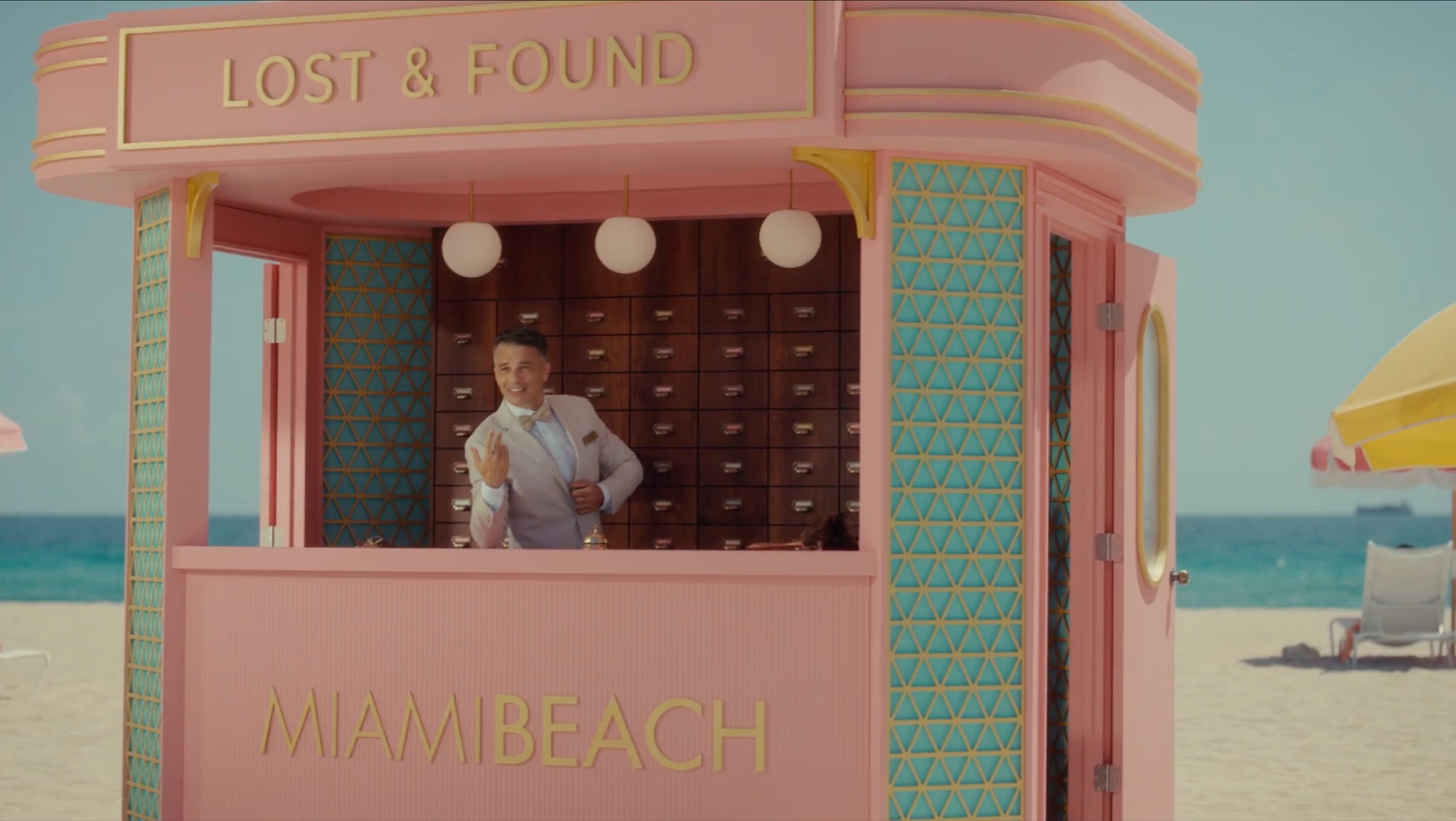 The pastel pink Miami Beach Lost & Found booth with Lorenzo Patane at the counter